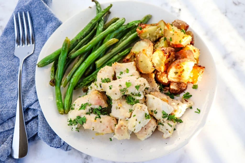 Roasted ranch chicken, potatoes and green beans on a plate.