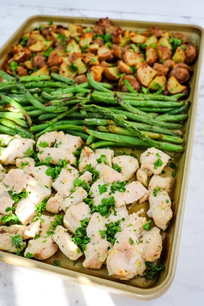 Roasted chicken breast chunks, green beans and potatoes on a sheet pan.